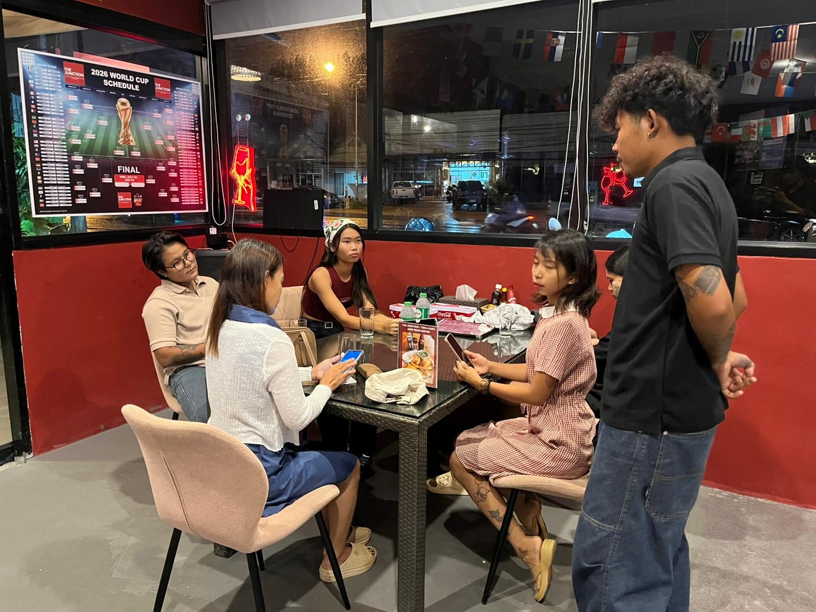Guests seated beneath a sports screen at The Junction